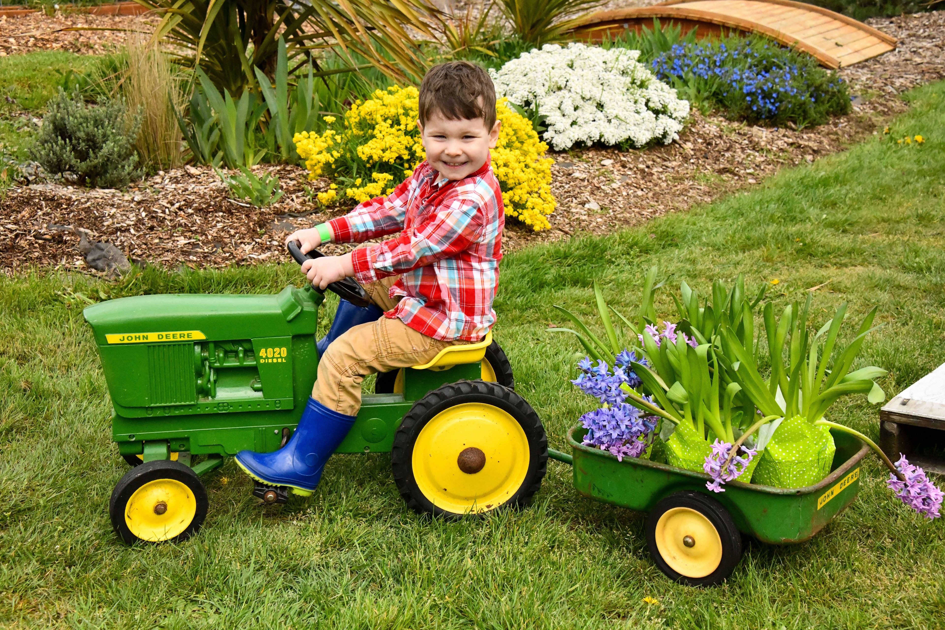 Child on tractor mowing lawn.